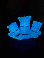 Tiki Team Hideout II photographed in a dark room, the prints glowing blue