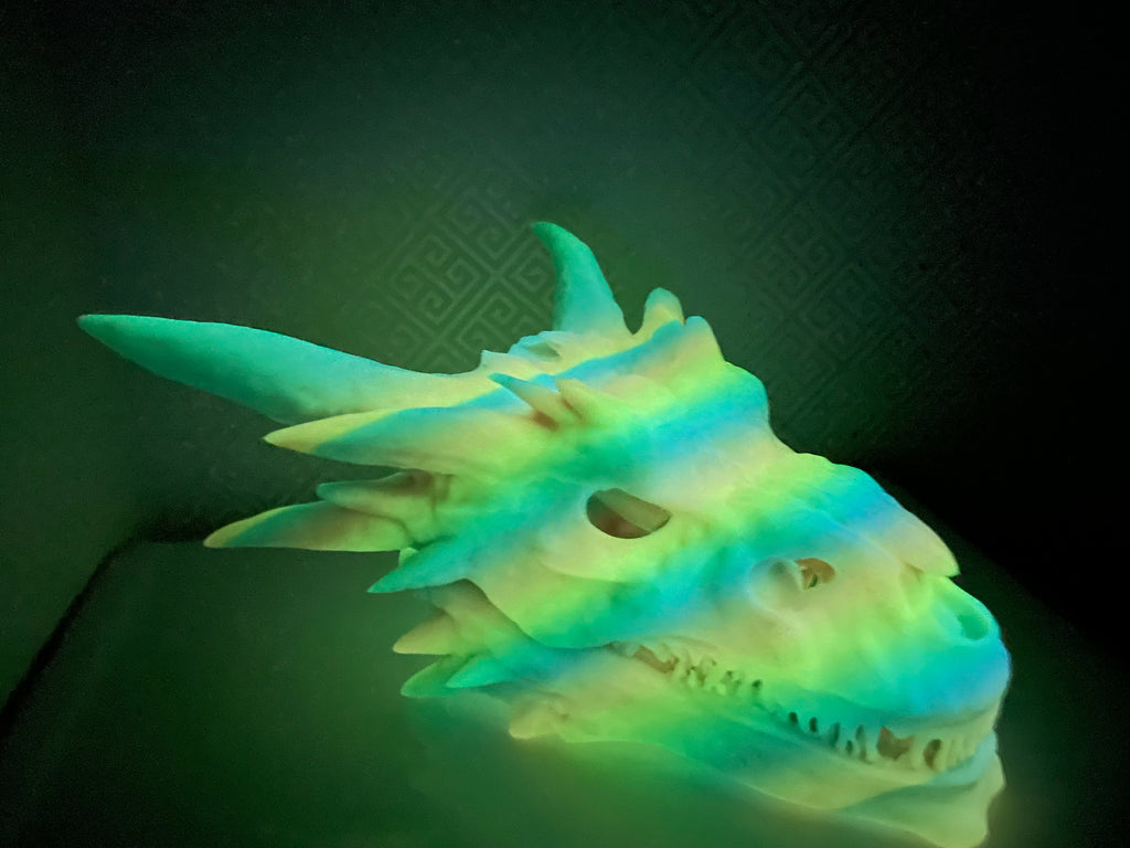 Dragon Skull Hide photographed in a dark room, the print glowing green