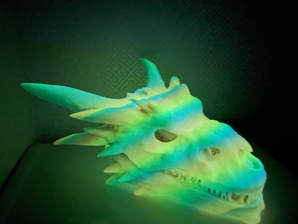 Dragon Skull Hide photographed in a dark room, the print glowing green